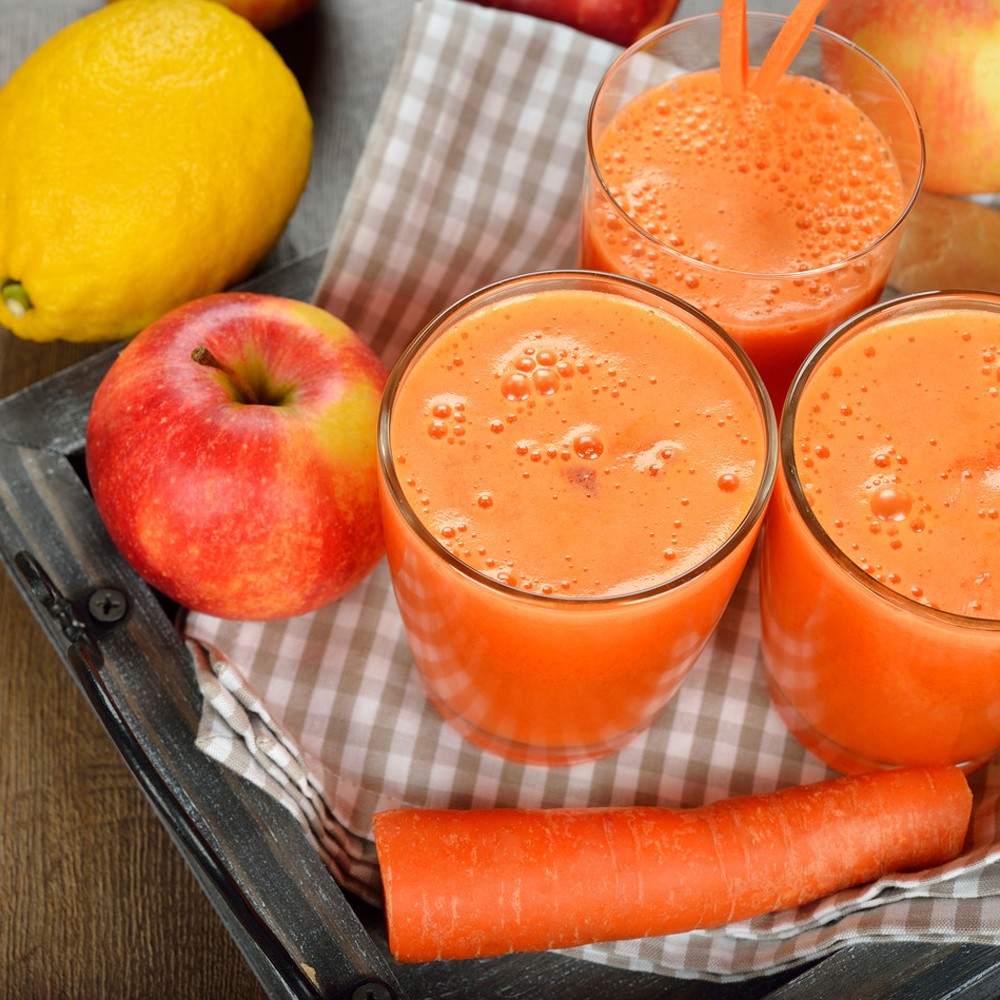 Fresh apple and carrot juice on brown background